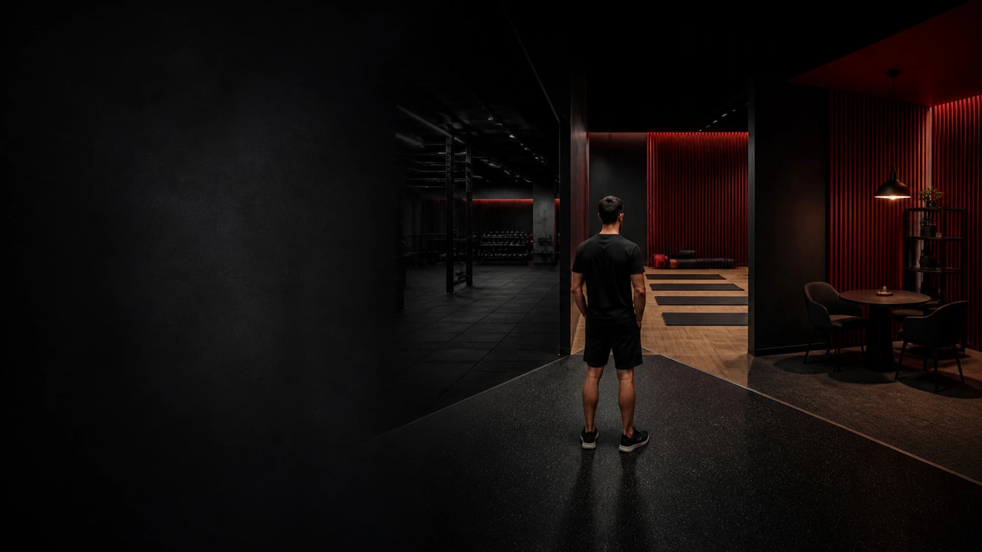 Cvičenec stojí mezi open gym zónou a prostorem pro vedené lekce.